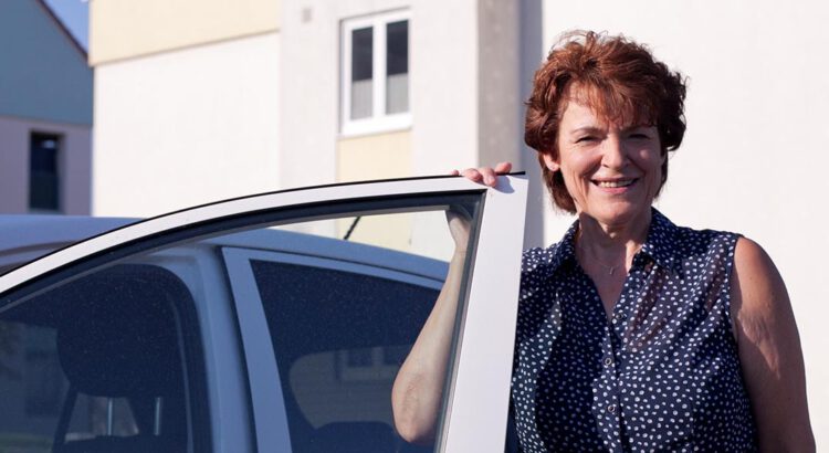Frau steht neben der Autotür